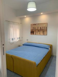 a bedroom with a bed with a painting on the wall at NERONE HOUSE in Diamante