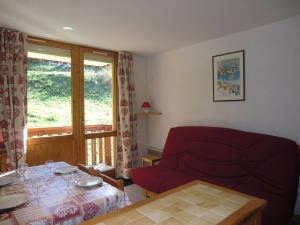 a living room with a red couch and a table at Appartement La Plagne Montalbert , 2 pièces, 5 personnes - FR-1-181-2463 in Aime-La Plagne