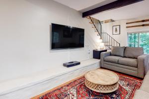 uma sala de estar com um sofá, uma mesa e uma televisão em Gunstock Getaway em Gilford