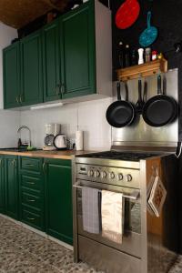 a kitchen with green cabinets and a stove with pots and pans at Palu Meeleolutalu 