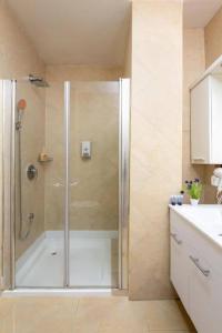 y baño con ducha y puerta de cristal. en H7 TLV, en Tel Aviv