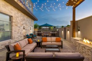 an outdoor patio with furniture and a fireplace at Hyatt House Bryan/College Station in College Station