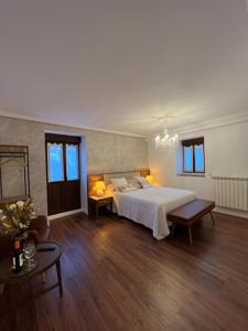 a bedroom with a white bed and wooden floors at Las Dos Peñas in Mier