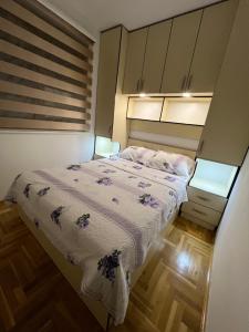um pequeno quarto com uma cama e 2 candeeiros em Apartment stan na dan Hilandarska em Lukavica