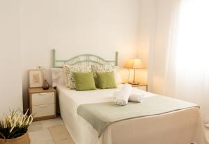 a white bedroom with a bed with towels on it at La Besana Home in Málaga