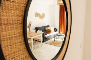 a living room with a couch and a table in a mirror at La Besana Home in Málaga