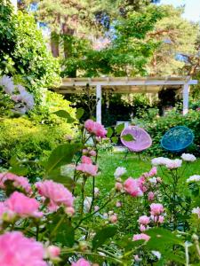 a garden with two chairs and pink flowers at Fisher House in Sopot