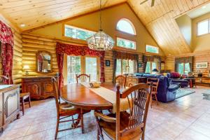 a dining room and living room with a wooden ceiling at White Mountain Log Home in Carroll