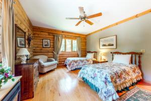 a bedroom with two beds and a ceiling fan at White Mountain Log Home in Carroll