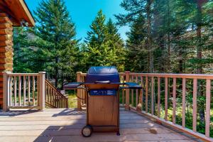 a barbecue grill sitting on a deck on a porch at White Mountain Log Home in Carroll