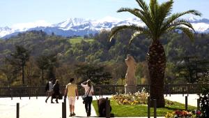 um grupo de pessoas andando em um parque com uma palmeira em La Fabrique Paloise em Pau