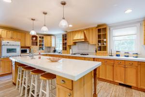 a kitchen with wooden cabinets and a large island with bar stools at Peaceful Pintail in Ocean Pines
