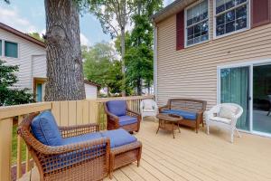 a deck with wicker chairs and tables and a tree at Peaceful Pintail in Ocean Pines