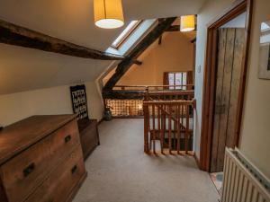 een zolderkamer met een houten dressoir en een trap bij Dairy House in Newton