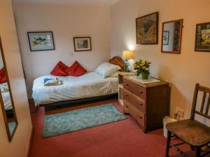 1 dormitorio pequeño con 1 cama y vestidor con escritorio en Dairy House, en Newton