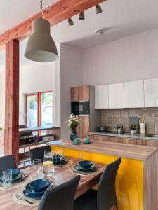 a kitchen with a wooden table with chairs and a dining room at Apartmán NIKLAN in Rožnov pod Radhoštěm