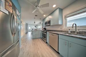 una grande cucina con armadi bianchi e frigorifero di Sunny, Modern Waterfront Cottage with Grill in Erie! a Erie