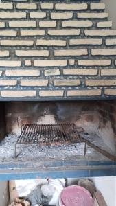 a person is cooking on a charcoal grill at Cecilia in General Alvarado