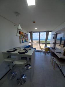 レシフェにあるFLAT BEIRA MAR BARRA DE JANGADA RECIFE ANDAR ALTOのキッチン、海の景色を望むダイニングルーム