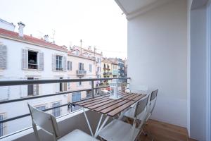 balkon z drewnianym stołem i krzesłami w obiekcie Tredici- Appartment w Cannes