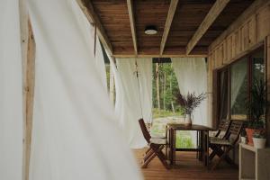 een veranda van een huis met een tafel en stoelen bij Secluded Holiday Home with Sauna in National Park by the Sea in Vaide