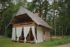 een klein huis met een gambrel dak en witte gordijnen bij Secluded Holiday Home with Sauna in National Park by the Sea in Vaide