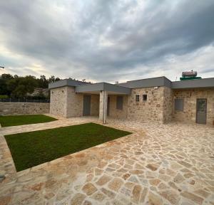a brick building with a grass yard in front of it at AG.Stone.Home in Isthmia