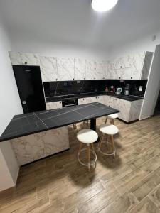 a kitchen with a black counter top and two stools at AG.Stone.Home in Isthmia