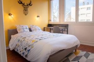 a bedroom with a bed and a table and windows at La Fabrique Paloise in Pau