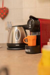 [NEL CUORE DELLA CITTADINA TERMALE] MAISON M&V في مونتيكاتيني تيرمي: وجود آلة صنع القهوة على طاولة مع كوب قهوة