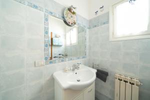 a bathroom with a sink and a mirror at [NEL CUORE DELLA CITTADINA TERMALE] MAISON M&V in Montecatini Terme