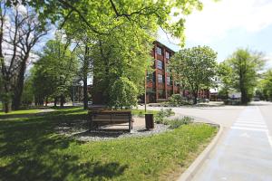 un banc de parc assis dans l'herbe devant un bâtiment dans l'établissement Apartimento Hydral Spero, à Wrocław