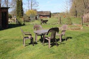 einen Tisch und Stühle im Gras auf einem Feld in der Unterkunft Rathsacks Familienhof in Ziegendorf