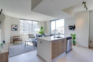 a kitchen with a sink and a living room at Amazing 2BR Condo At Crystal City With Rooftop in Arlington