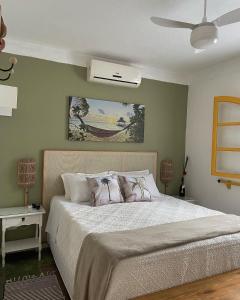 een slaapkamer met een bed en een plafondventilator bij Hospedaria do Marquês in Boicucanga