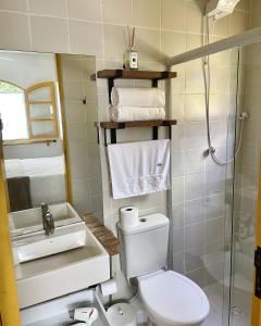 a bathroom with a toilet and a sink and a shower at Hospedaria do Marquês in Boicucanga