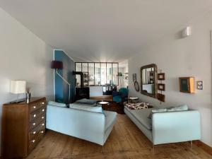 a living room with a couch and a mirror at Pépite au plein centre historique in Lons-le-Saunier