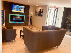 a living room with two couches and a flat screen tv at BlissPoint Inn Northwest Indianapolis in Indianapolis