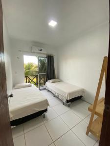 dwa łóżka w pokoju z oknem w obiekcie Apartamento Taiba! w mieście Taíba +17 zdjęć