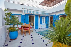 a blue and white house with a table and chairs at Riad Ocean View - Entire Accommodation in Rabat