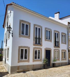 Cette maison blanche dispose de fenêtres et d'une porte. dans l'établissement Villa Alva Guest House, à Coja