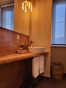a bathroom with a sink and a mirror at Villa Alva Guest House in Coja