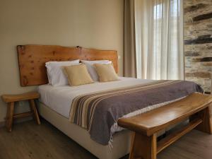 um quarto com uma cama com uma cabeceira em madeira e uma janela em Villa Alva Guest House em Coja