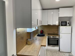 a kitchen with white cabinets and a white refrigerator at Amigi in Sarajevo