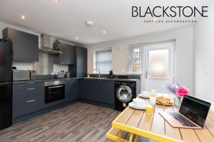 a kitchen with a table with a laptop on it at Island House - 3 Bedroom Townhouse by BPNE in Darlington