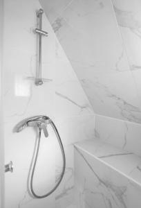a shower in a bathroom with white marble walls at Beautiful apartment with a view of Eiffel Tower in center Paris in Paris