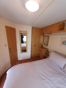 a bedroom with a large white bed and a mirror at Fantasy Island 6 Berth 576 in Ingoldmells