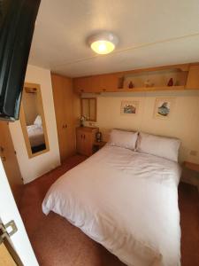 a bedroom with a large white bed in it at Fantasy Island 6 Berth 576 in Ingoldmells