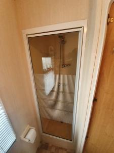 a bathroom with a shower with a toilet and a mirror at Fantasy Island 6 Berth 576 in Ingoldmells +22 photos