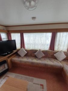 a living room with a couch and a flat screen tv at Fantasy Island 6 Berth 576 in Ingoldmells